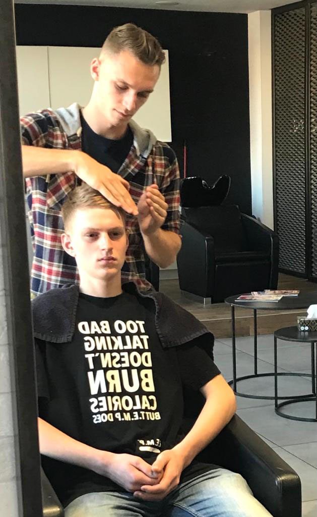 barber układa włosy młodego chłopaka