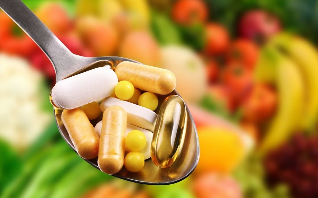 Suplementy diety tabletki pastylki na łyżce z owocami